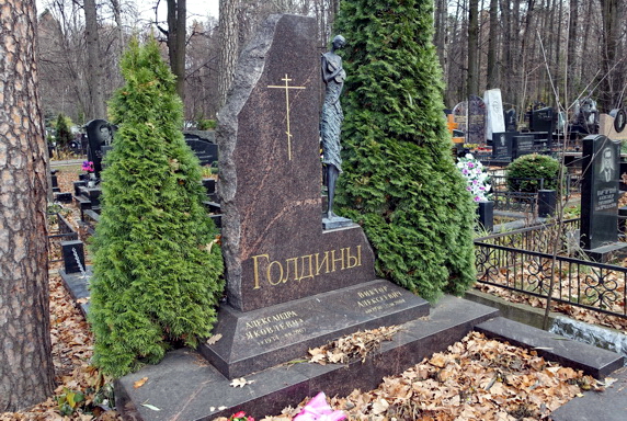 Надгробье со скульптурой скрипачки в окружении двух туй